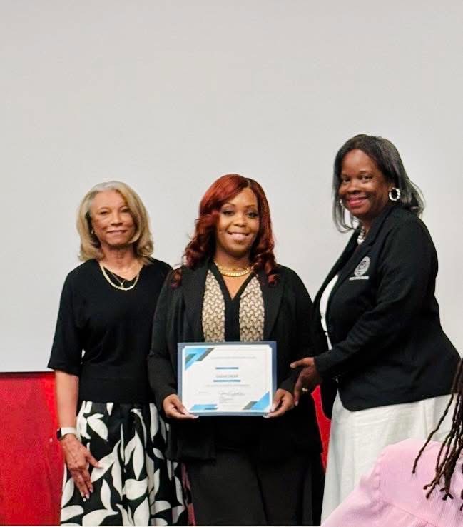 Sarah C. Swann receiving a leadership cohort certificate alongside two community leaders.